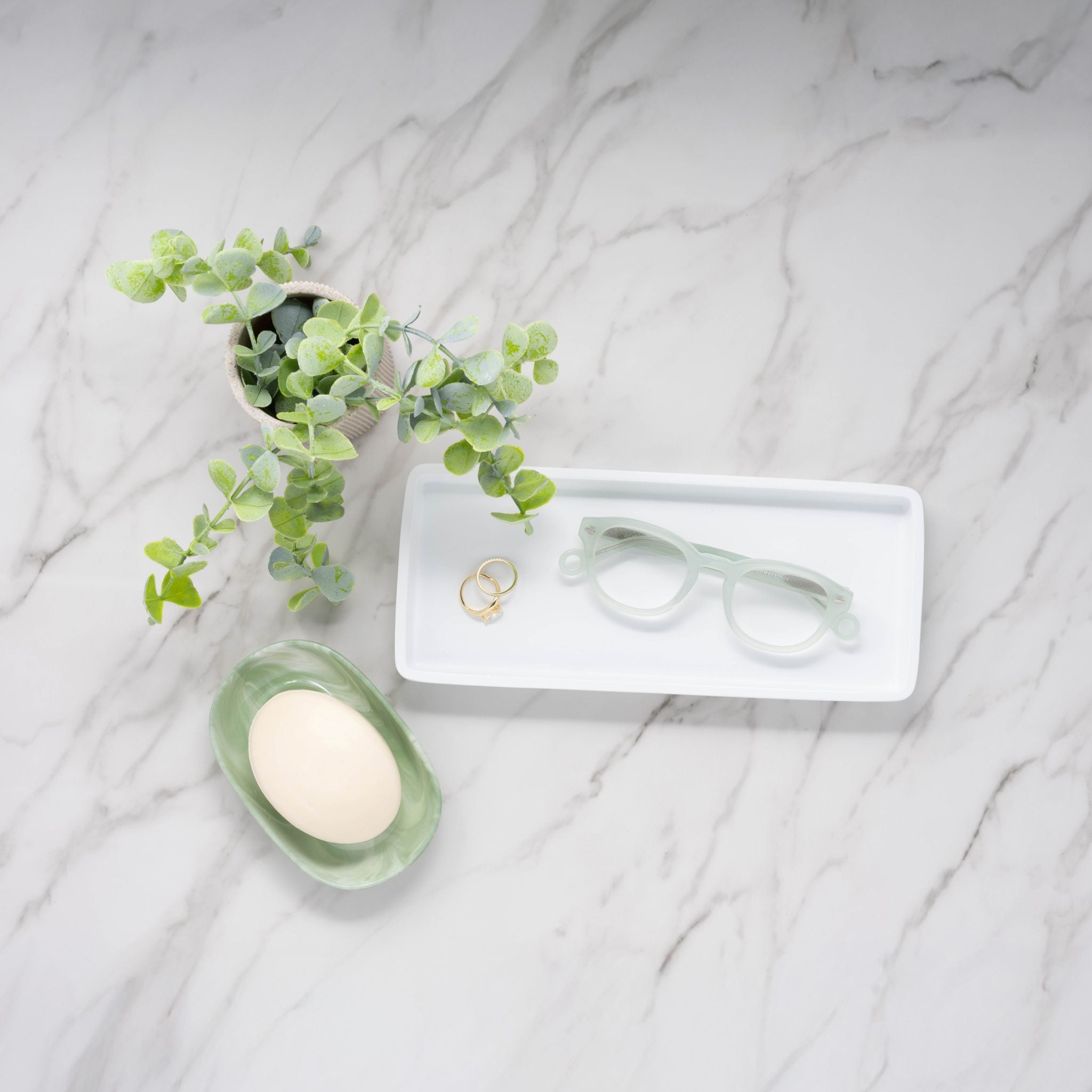 Misty Green Showerspecs anti-fog reading glasses on a marble countertop. 