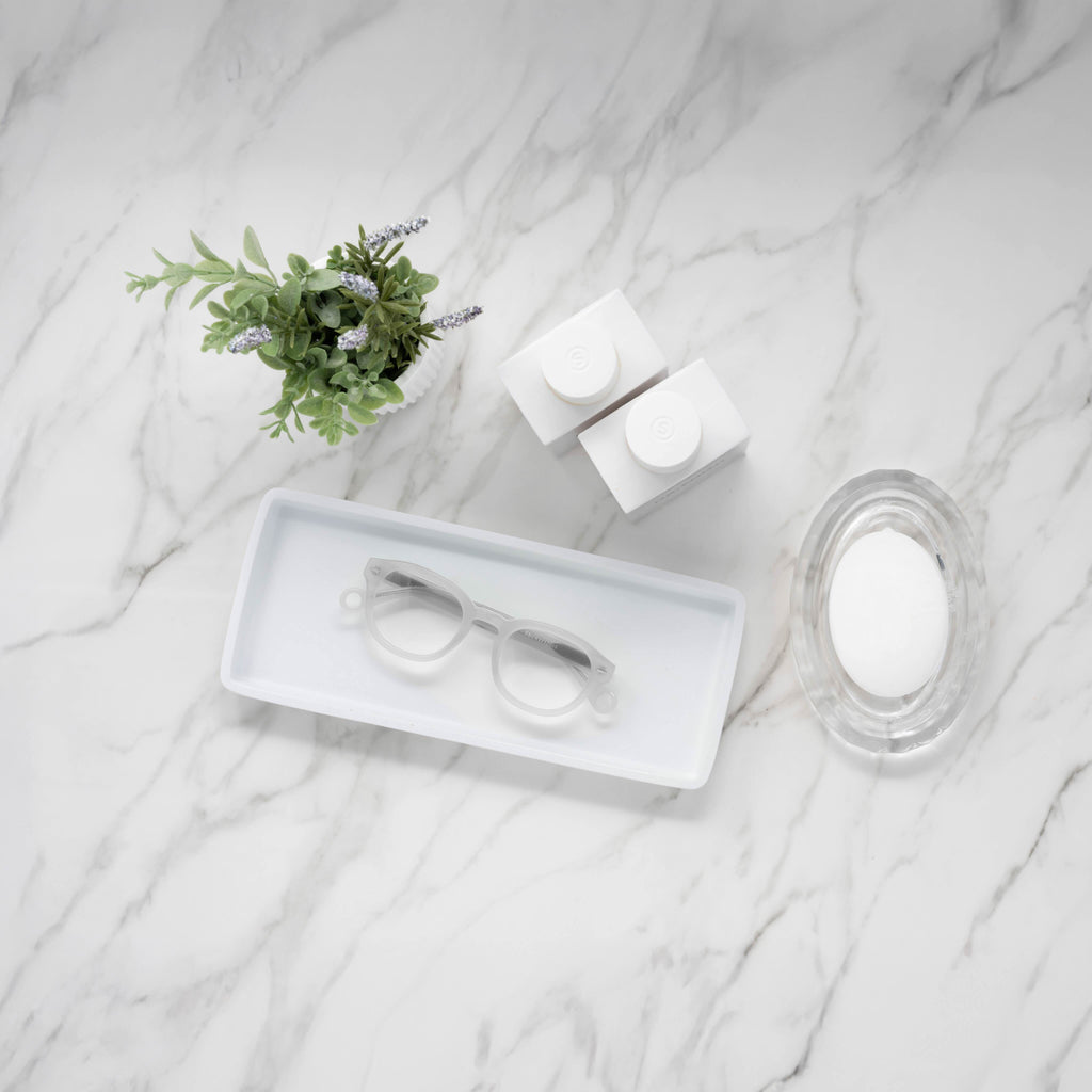 Showerspecs reading glasses on a bathroom countertop.