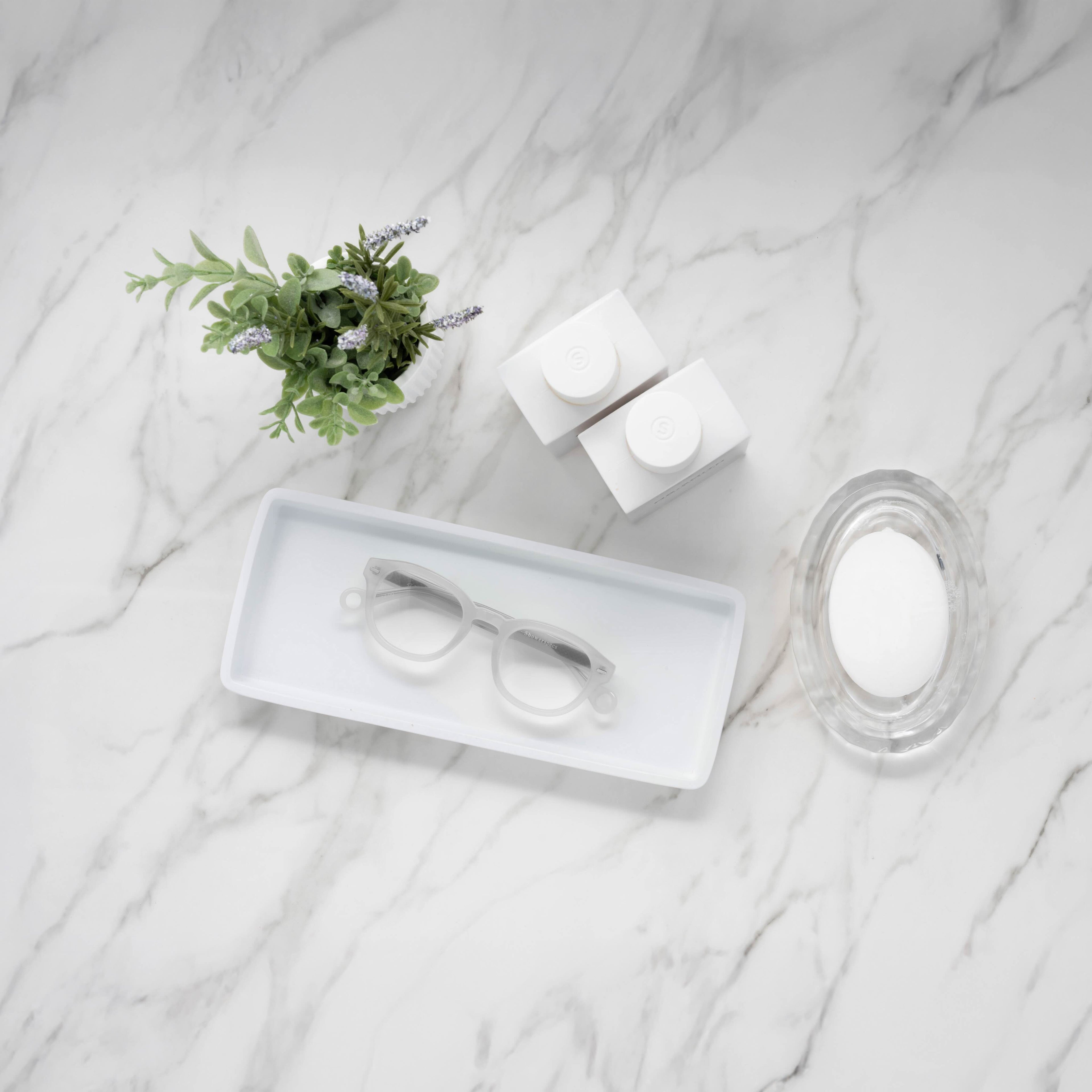 Showerspecs reading glasses on a bathroom countertop.