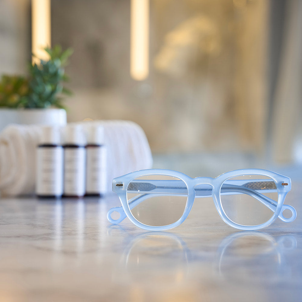 Pastel Blue Showerspecs reading glasses on a spa countertop.