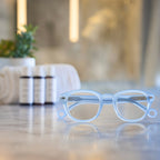 Pastel Blue Showerspecs reading glasses on a spa countertop.